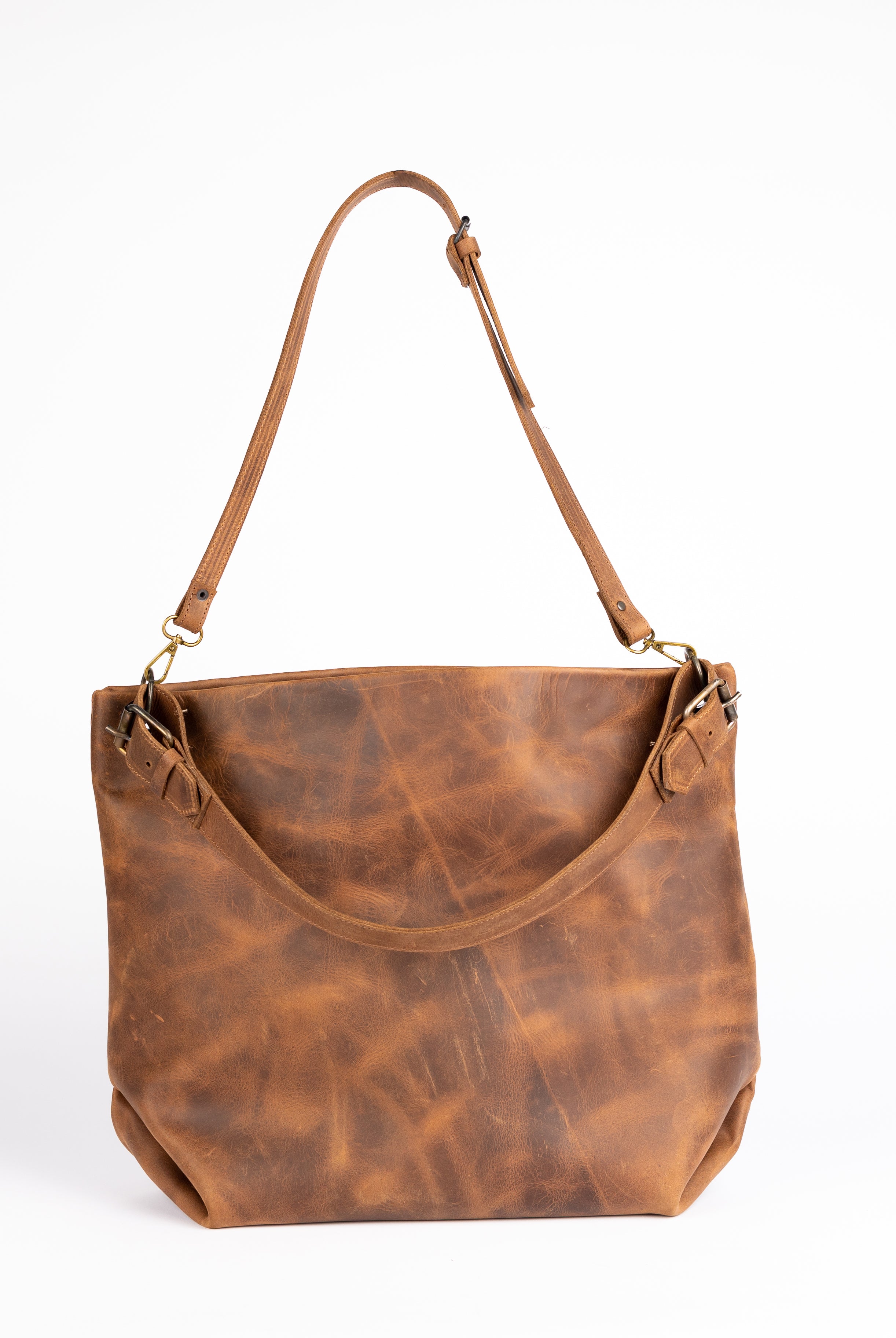 Rear perspective of the Parisian Tote displaying dual side buckles, natural leather creasing, and clean lines. This view captures the back panel’s grain pattern and hand-sewn craftsmanship.
